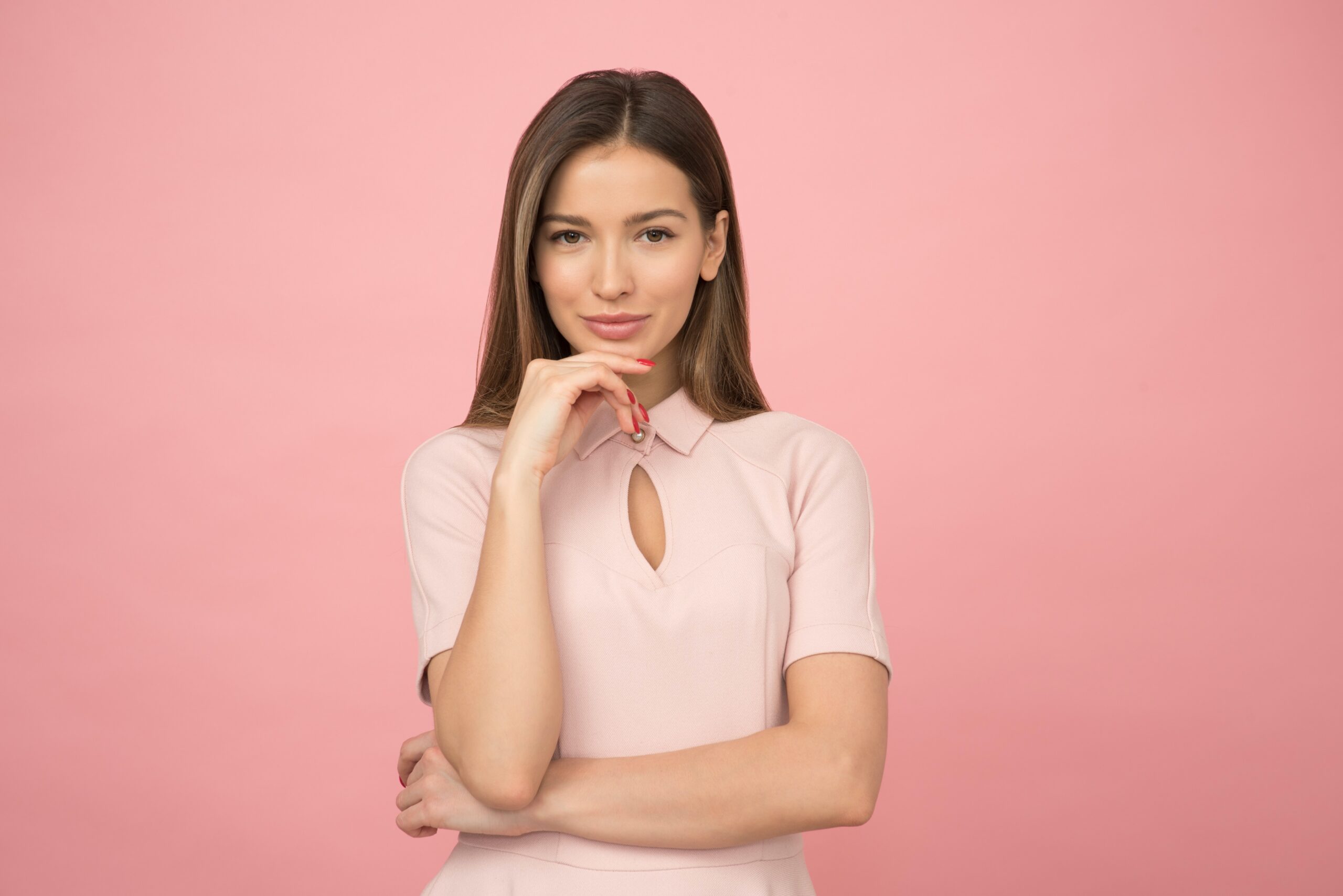 business woman standing against pink background