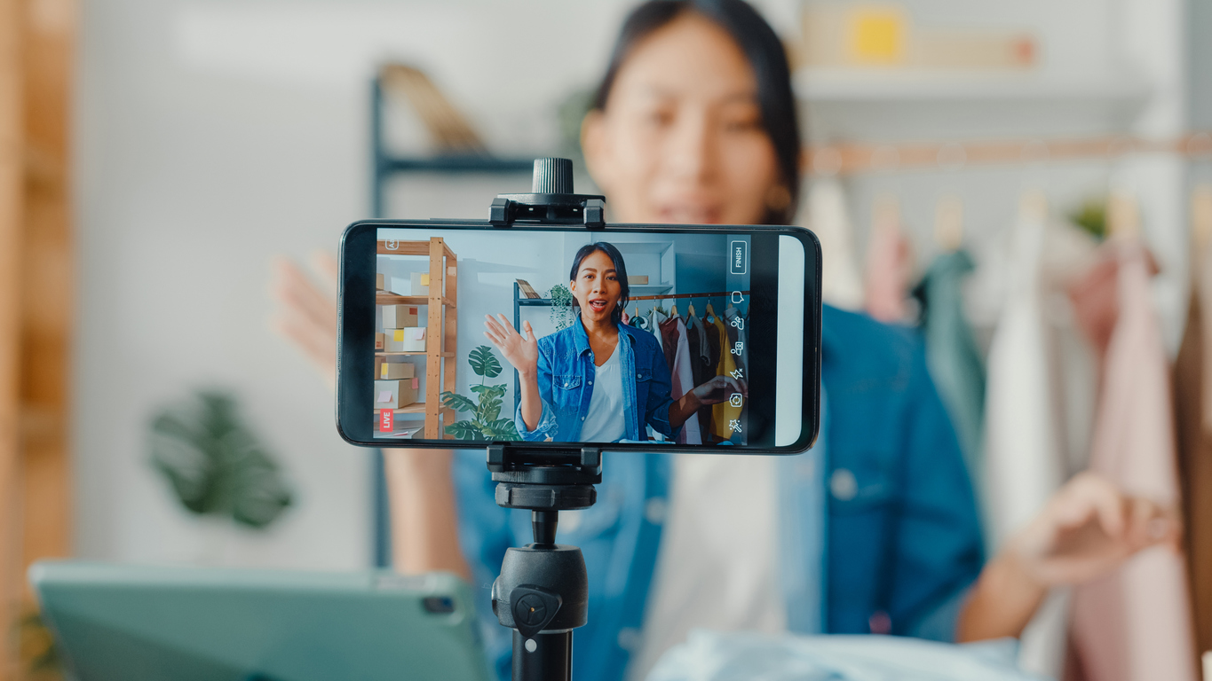 A woman records a video on her phone