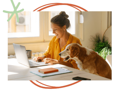 Woman business owner working on laptop with dog